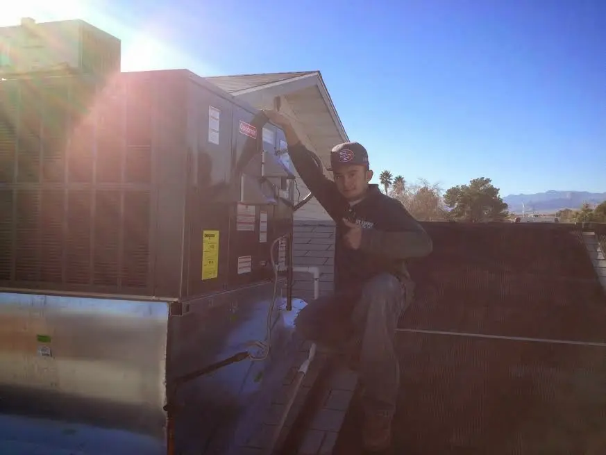 HVAC technician performing Air Duct Repair on a rooftop unit in Marietta